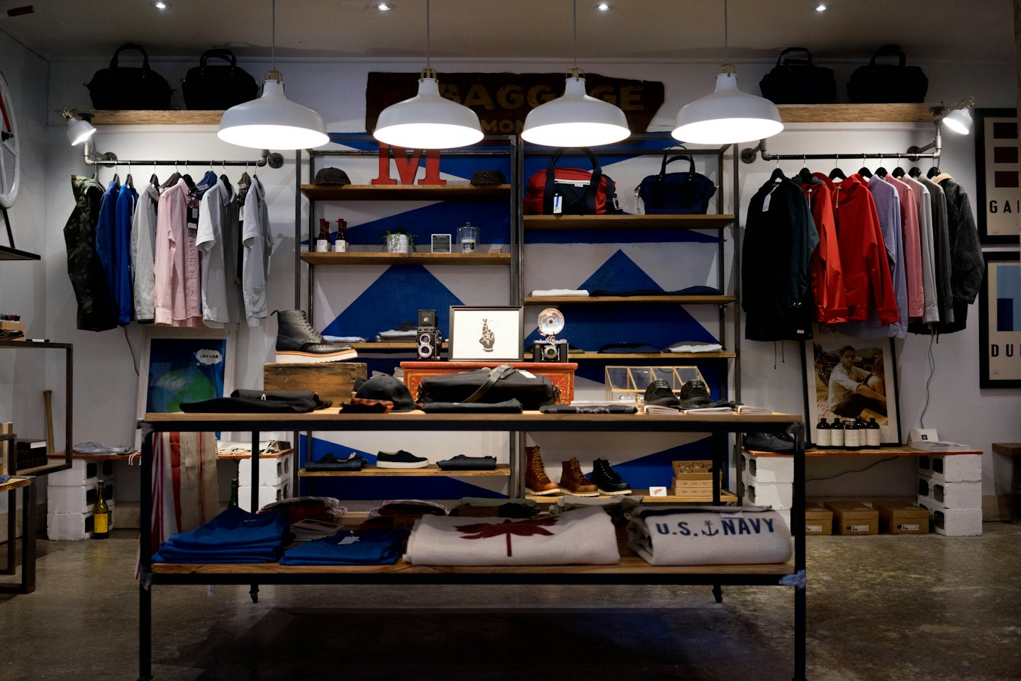 Modernes Bekleidungsgeschäft mit Kleidung, Schuhen und Accessoires in Regalen.